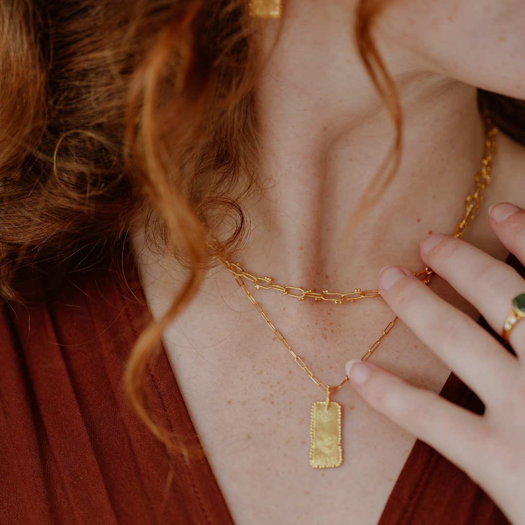 Add a touch of elegance to your look with this necklace, featuring a rectangular pendant in rich gold vermeil and organic textures.