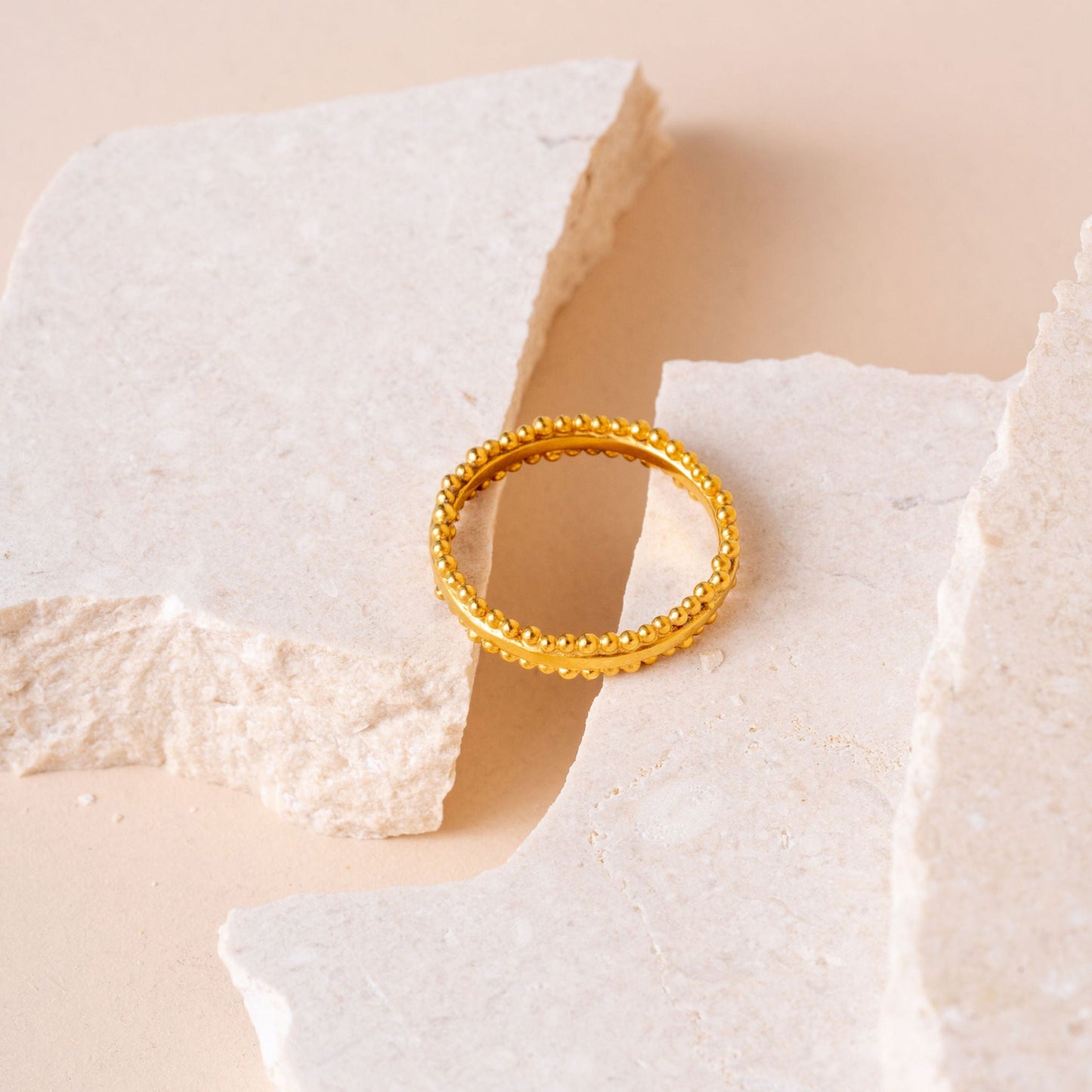Rich gold ring featuring delicate granulation around the top and bottom.