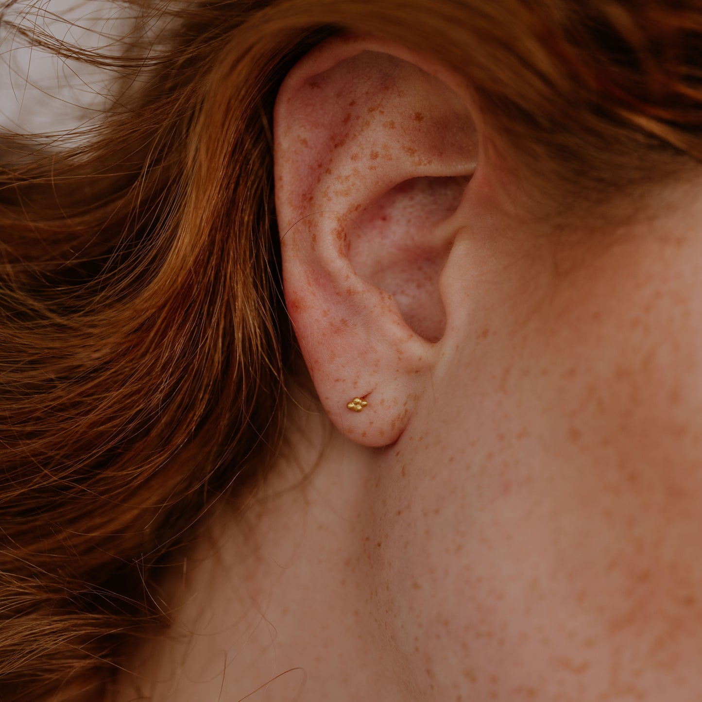 Artisan gold stud earrings, tiny and detailed.