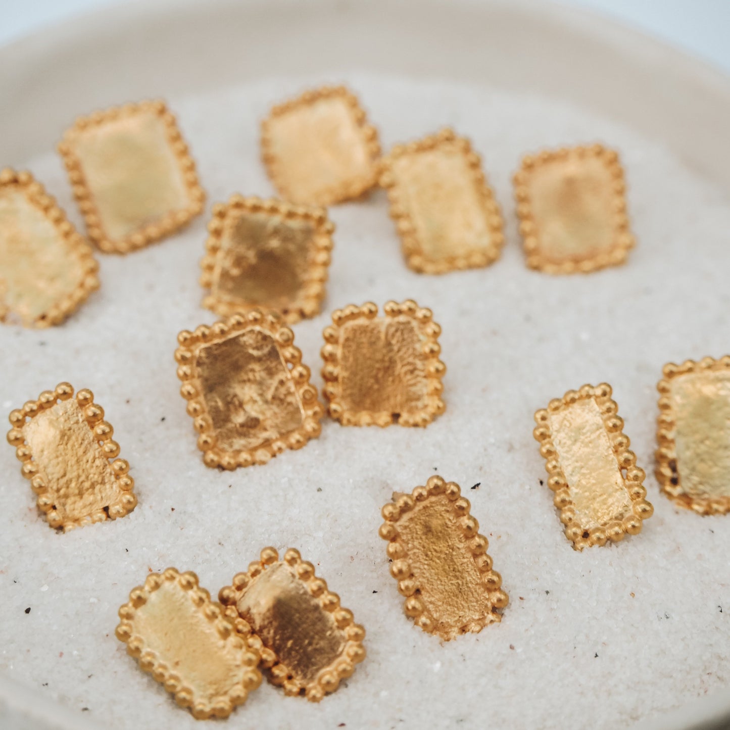 Classic square gold stud earrings adorned with intricate granulated patterns, adding a touch of sophistication.