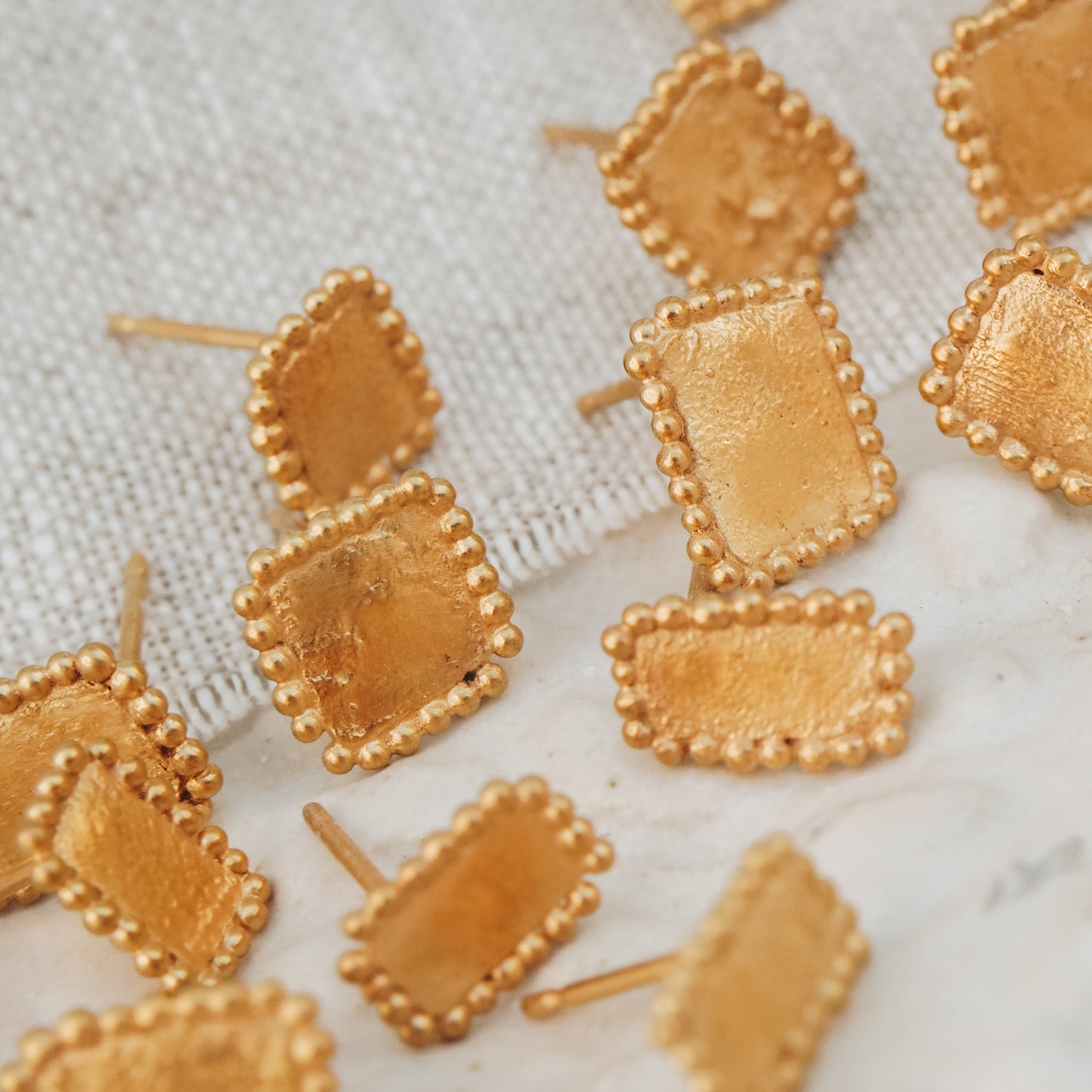 Intricately designed square gold stud earrings featuring delicate granulation