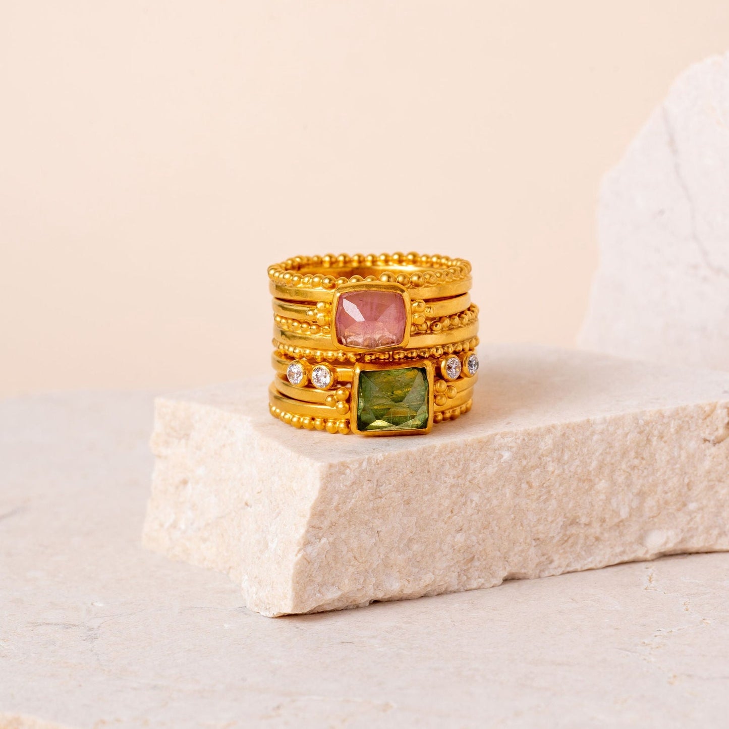 Unique gold granulated ring among a collection of artisan-crafted gemstone rings