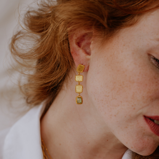 Elegant earrings featuring rich gold color and organic textures, adorned with unusual green tourmaline gemstones.