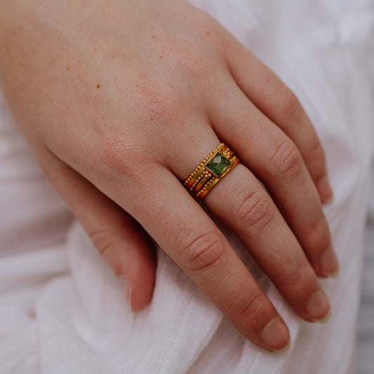 Exquisite gold ring featuring delicate granulation detail and a striking green rose-cut square tourmaline.