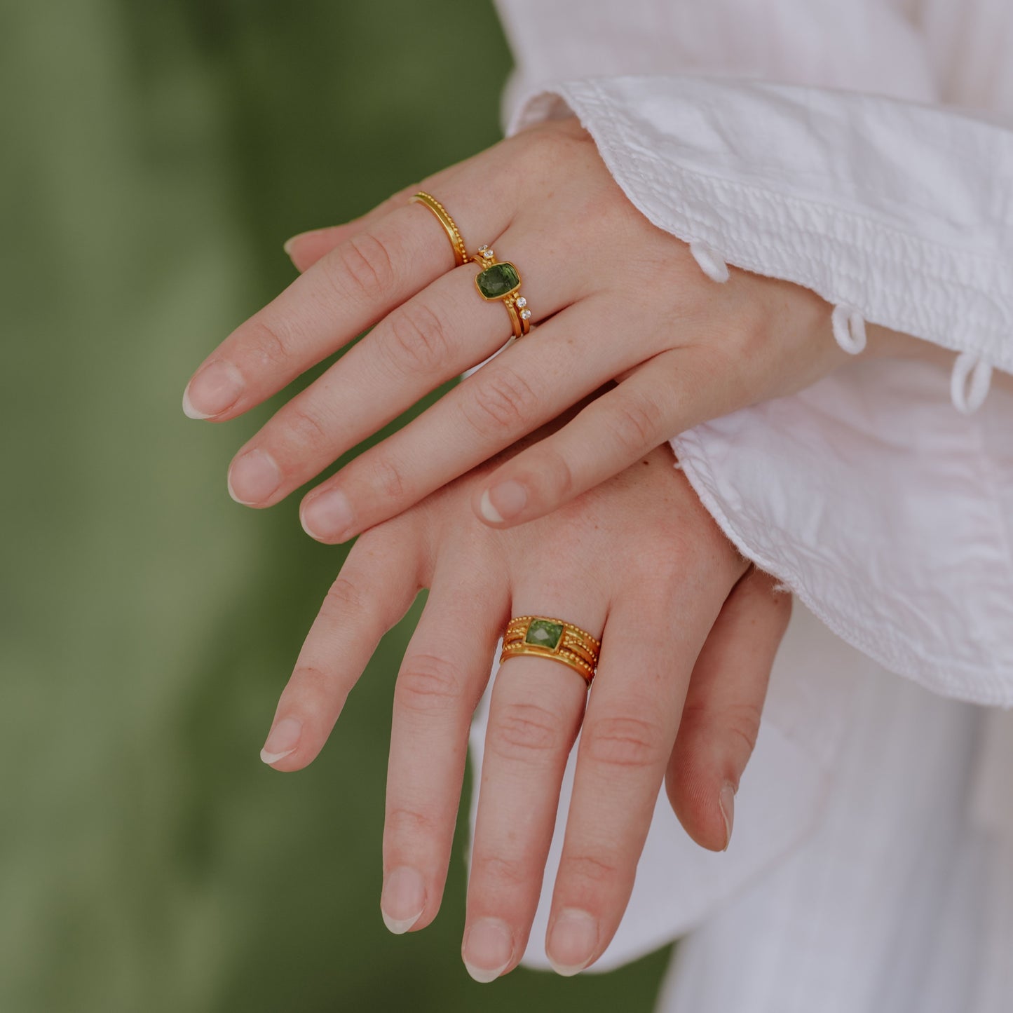 A stunning display of handcrafted gold rings, expertly detailed with granulation, and centred around natural green tourmaline gemstones.