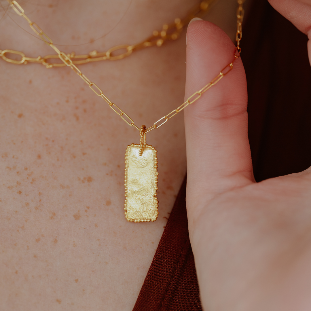 Crafted with an ancient aesthetic in mind, this necklace showcases a modern chain style and exquisite granulation detailing on its rectangular pendant.
