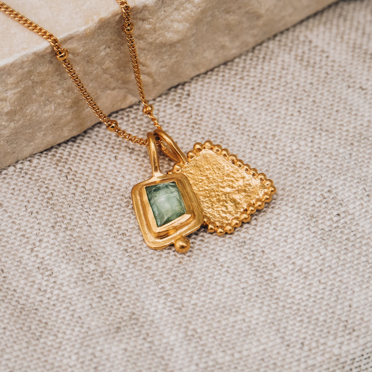 Square gold pendant featuring a breathtaking blue rose cut tourmaline gemstone and intricate granulation work, suspended from a dainty satellite chain.