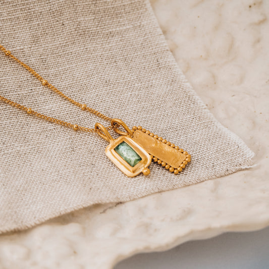Artisan-crafted square gold pendant with a captivating blue rose cut tourmaline gemstone and delicate granulation detail, suspended from a fine satellite chain.