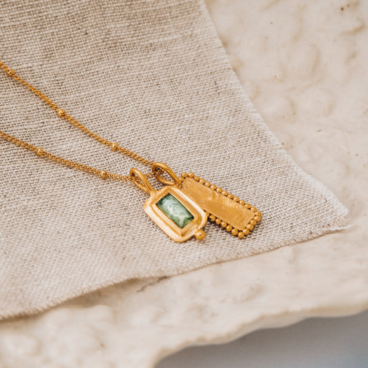 Artisan-crafted square gold pendant with a captivating blue rose cut tourmaline gemstone and delicate granulation detail, suspended from a fine satellite chain.