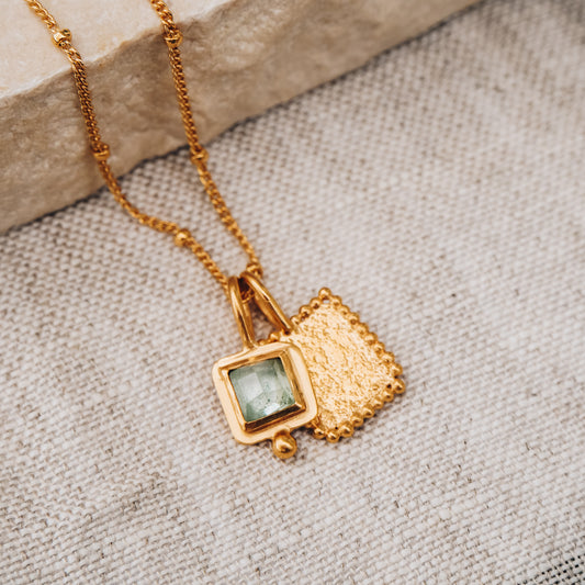 Timeless square gold pendant showcasing a mesmerizing blue rose cut tourmaline gemstone and delicate granulation detail, suspended from a dainty satellite chain.