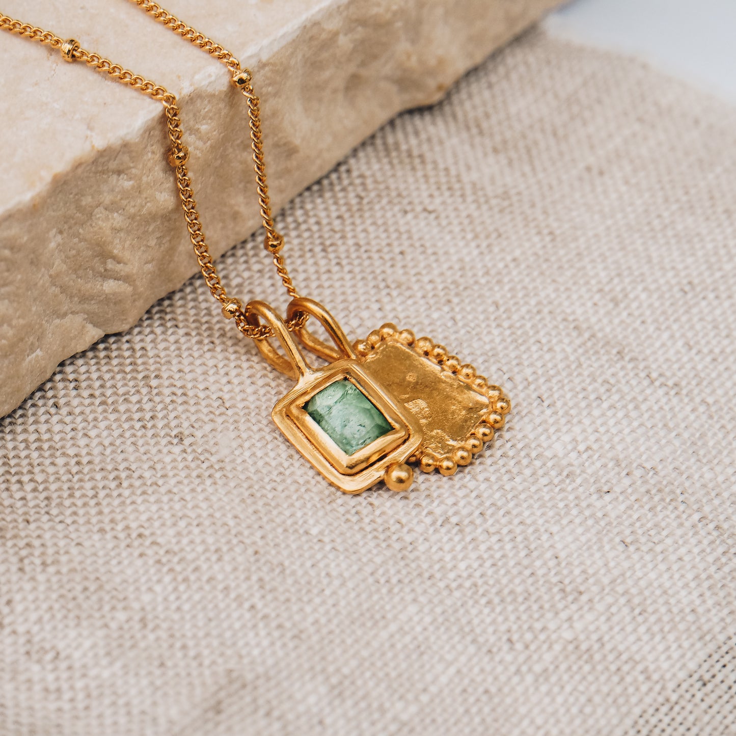 Artisan-crafted square gold pendant showcasing a stunning blue rose cut tourmaline gemstone and exquisite granulation work, hanging from a delicate satellite chain.