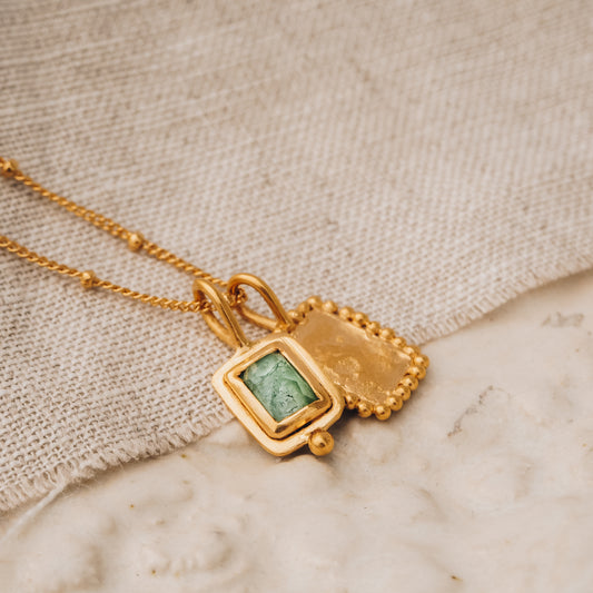 Handmade square gold pendant with a mesmerizing blue rose cut tourmaline gemstone and delicate granulation, elegantly hanging from a satellite chain.