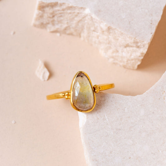 Handcrafted gold ring with delicate granulation surrounding a stunning teardrop-shaped yellow sapphire.