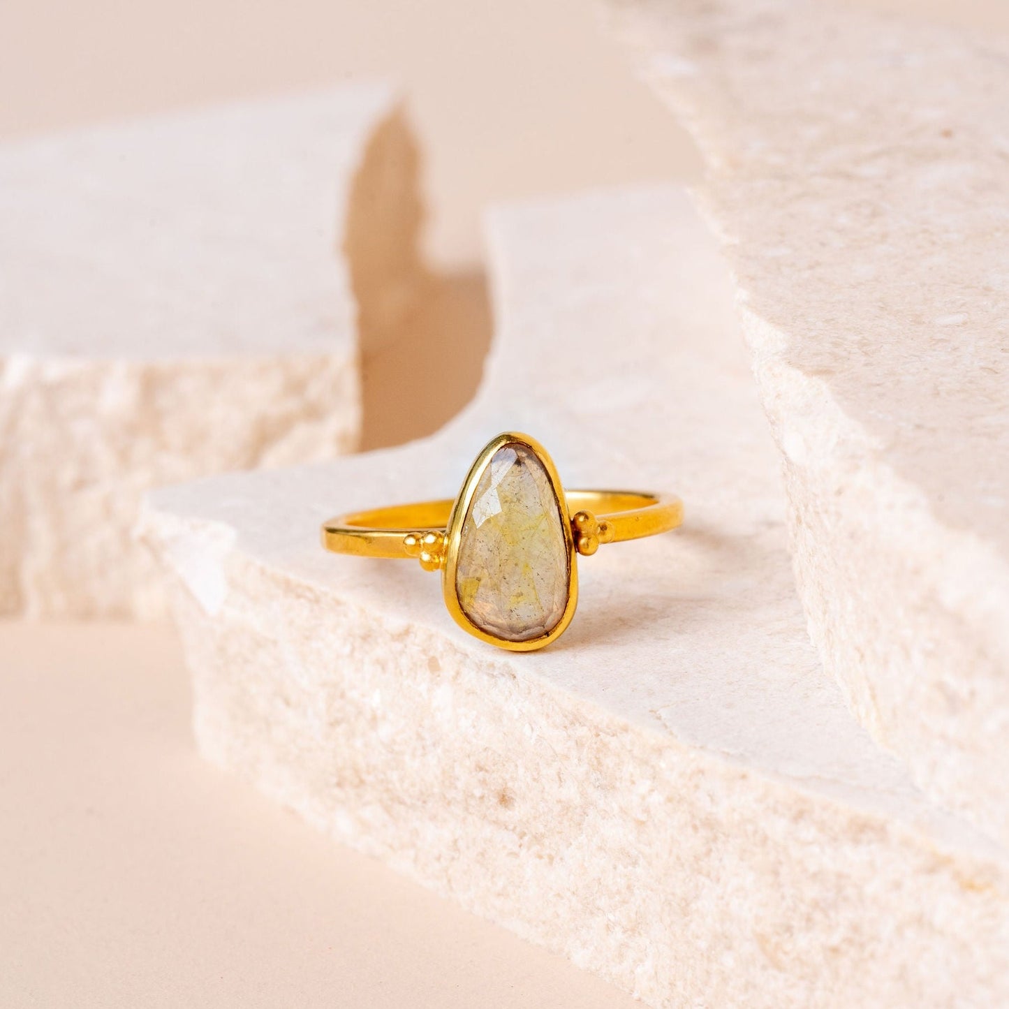 Handmade gold ring adorned with a graceful teardrop-shaped yellow sapphire and granulation accents.