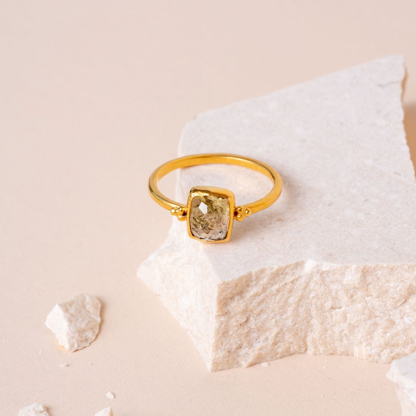 A stunning handcrafted gold ring, highlighted by deliacte granulation work, encasing a captivating olive-hued hand-cut gemstone.