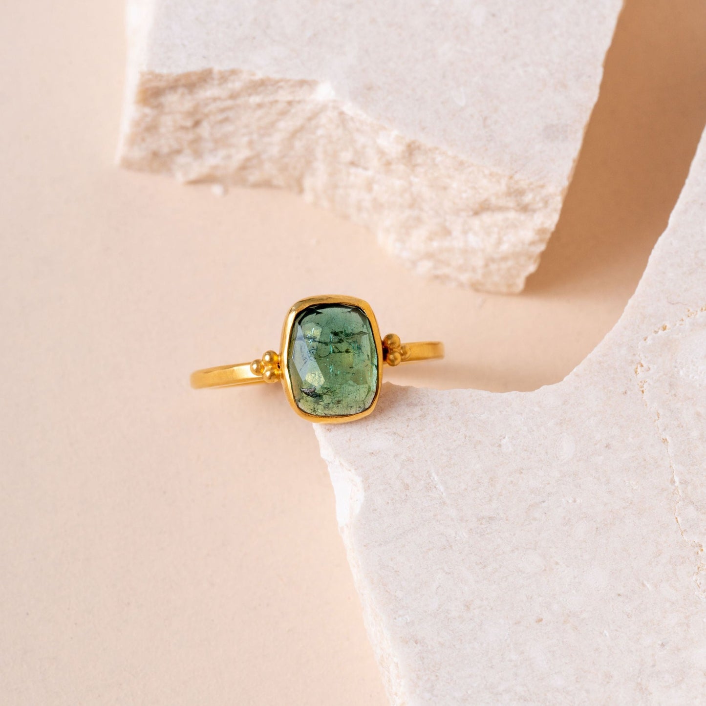 Solo shot of a captivating gold ring, expertly crafted with granulation details and featuring a mesmerizing green tourmaline gemstone.