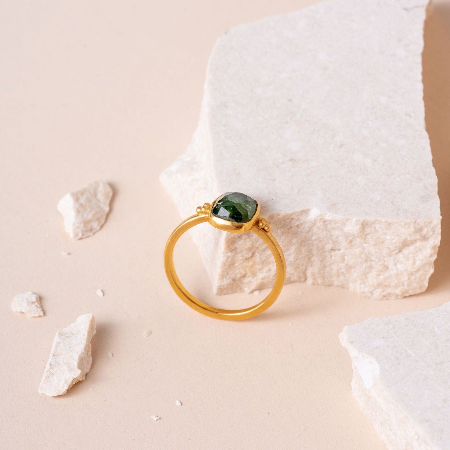 Elegantly captured gold ring, designed with meticulous granulation and accentuated by a single, vibrant green tourmaline gemstone