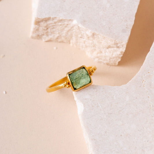 Handcrafted gold ring showcasing meticulous granulation work, complemented by a stunning green square tourmaline.