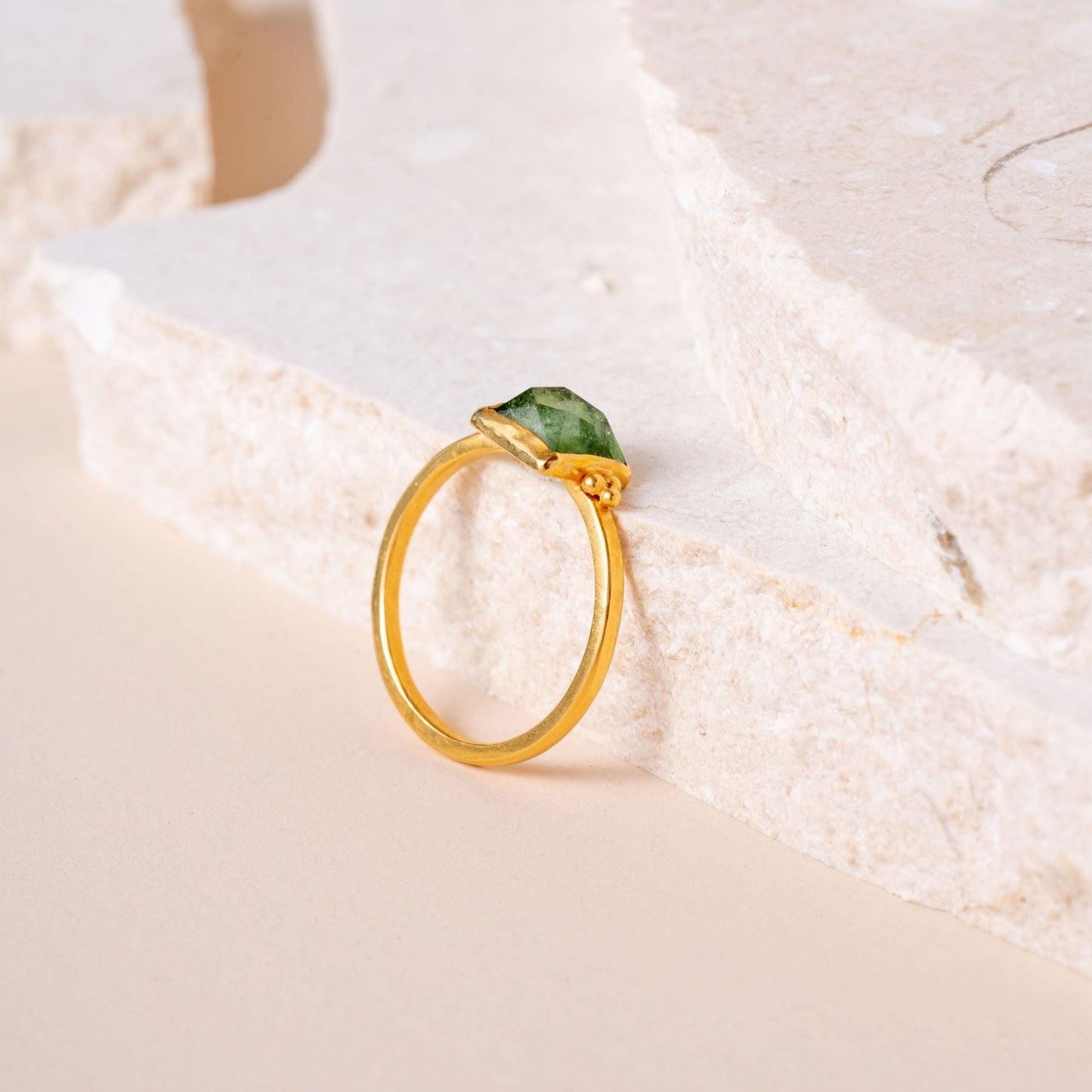A timeless gold ring, meticulously crafted with granulation details, showcasing a beautiful green rose-cut square tourmaline.