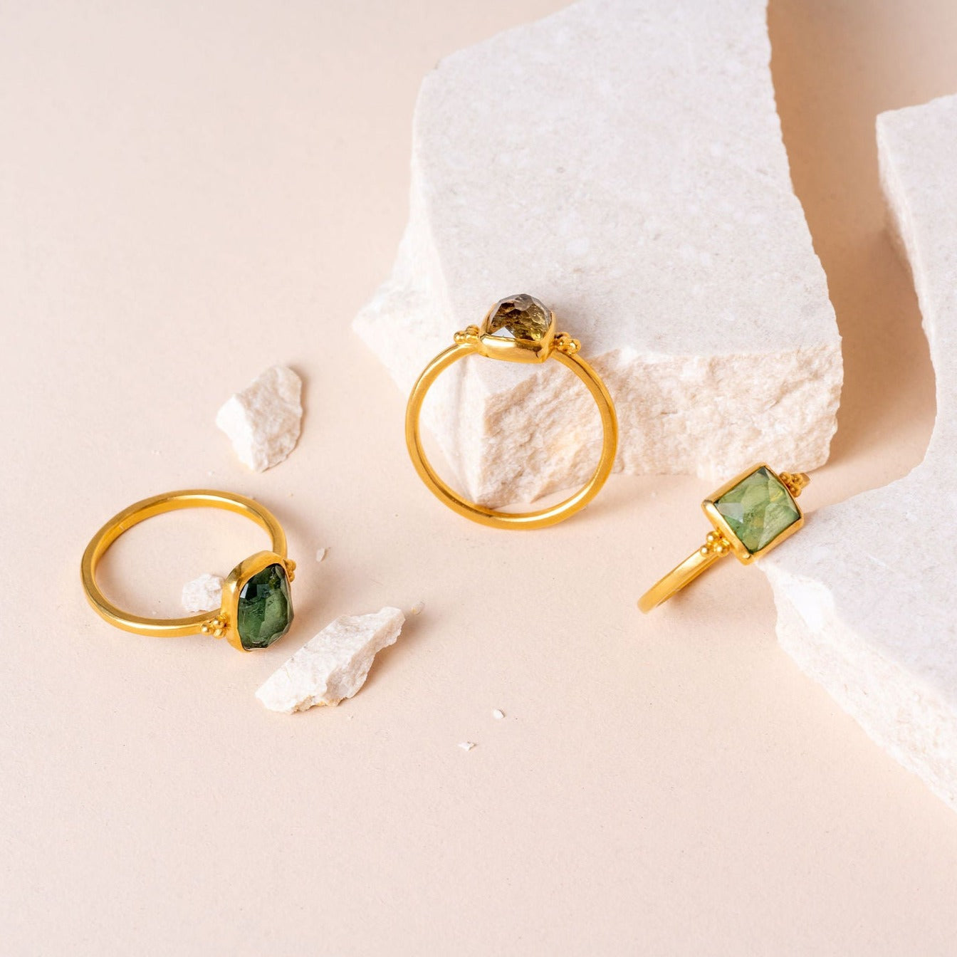 A group of three handcrafted gold vermeil rings featuring delicate granulation detailing and rose cut gemstones in shades of green.