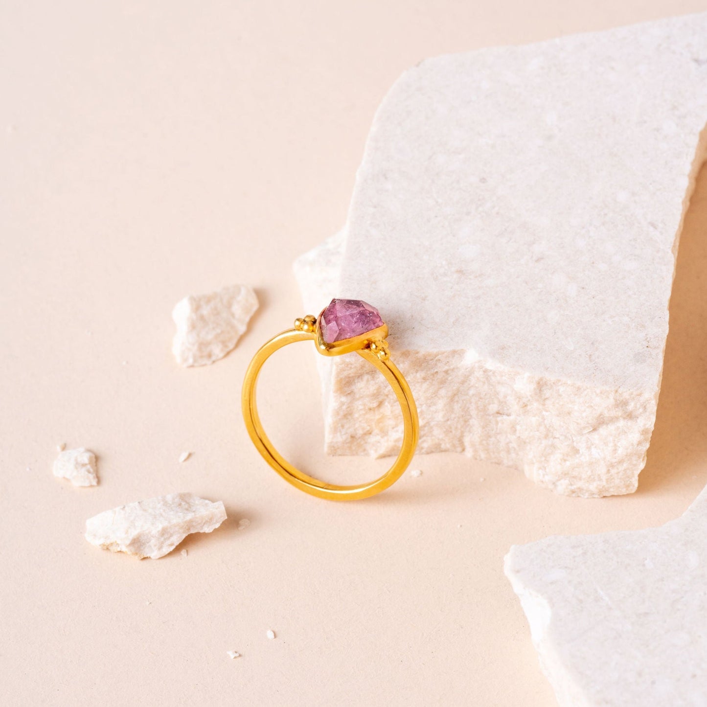 Indulge in simplicity and beauty with this gold ring, adorned with a delicate pink tourmaline gem and intricate granulation.