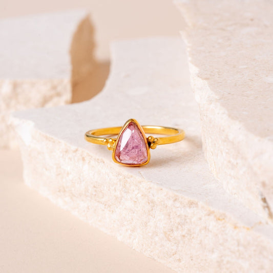 A unique gold ring with a charming pink tourmaline gem, handcrafted for a distinct and elegant look.