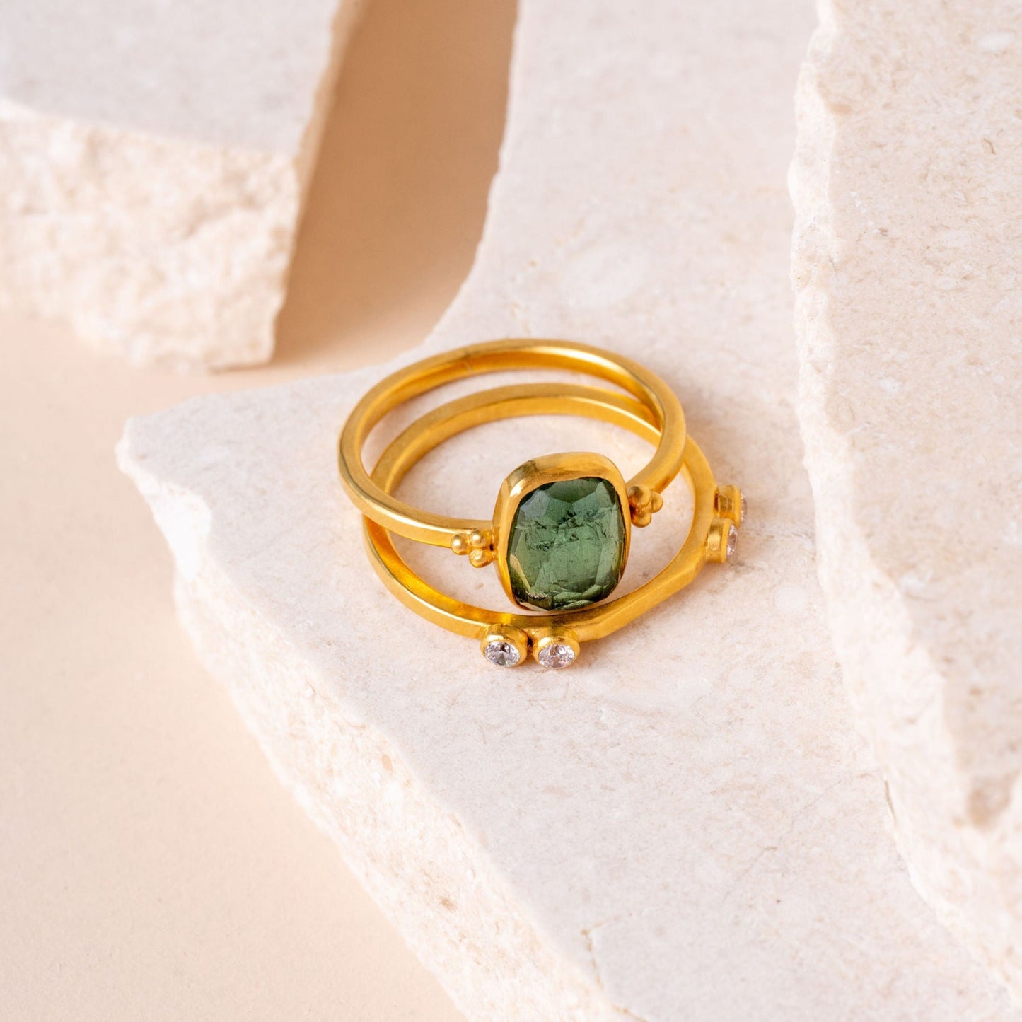 A captivating ensemble of handcrafted gold rings, showcasing intricate granulation details and featuring stunning forest green tourmaline gemstones