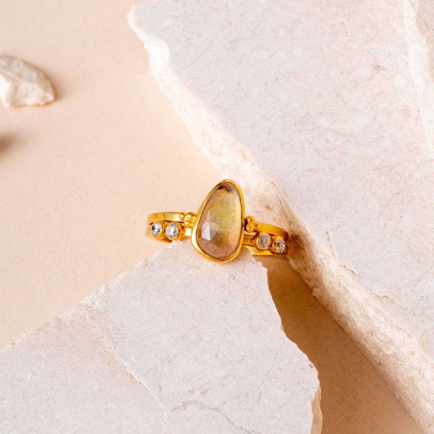 Artisan gold ring featuring a light yellow teardrop sapphire and intricate granulation details.
