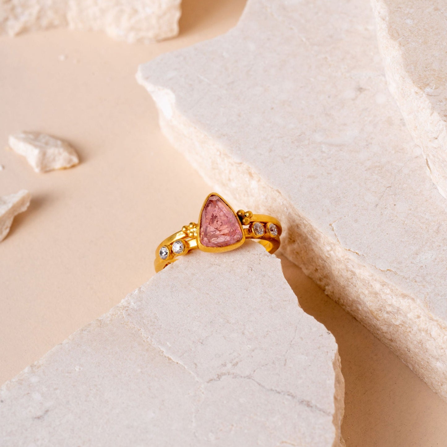 gold ring showcasing a hand-cut pink tourmaline, crafted with artistry and granulation accents.