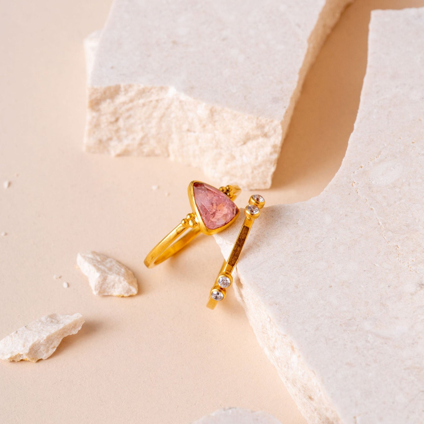 A rich gold coloured ring, expertly crafted to highlight a stunning pink tourmaline gem and detailed granulation.
