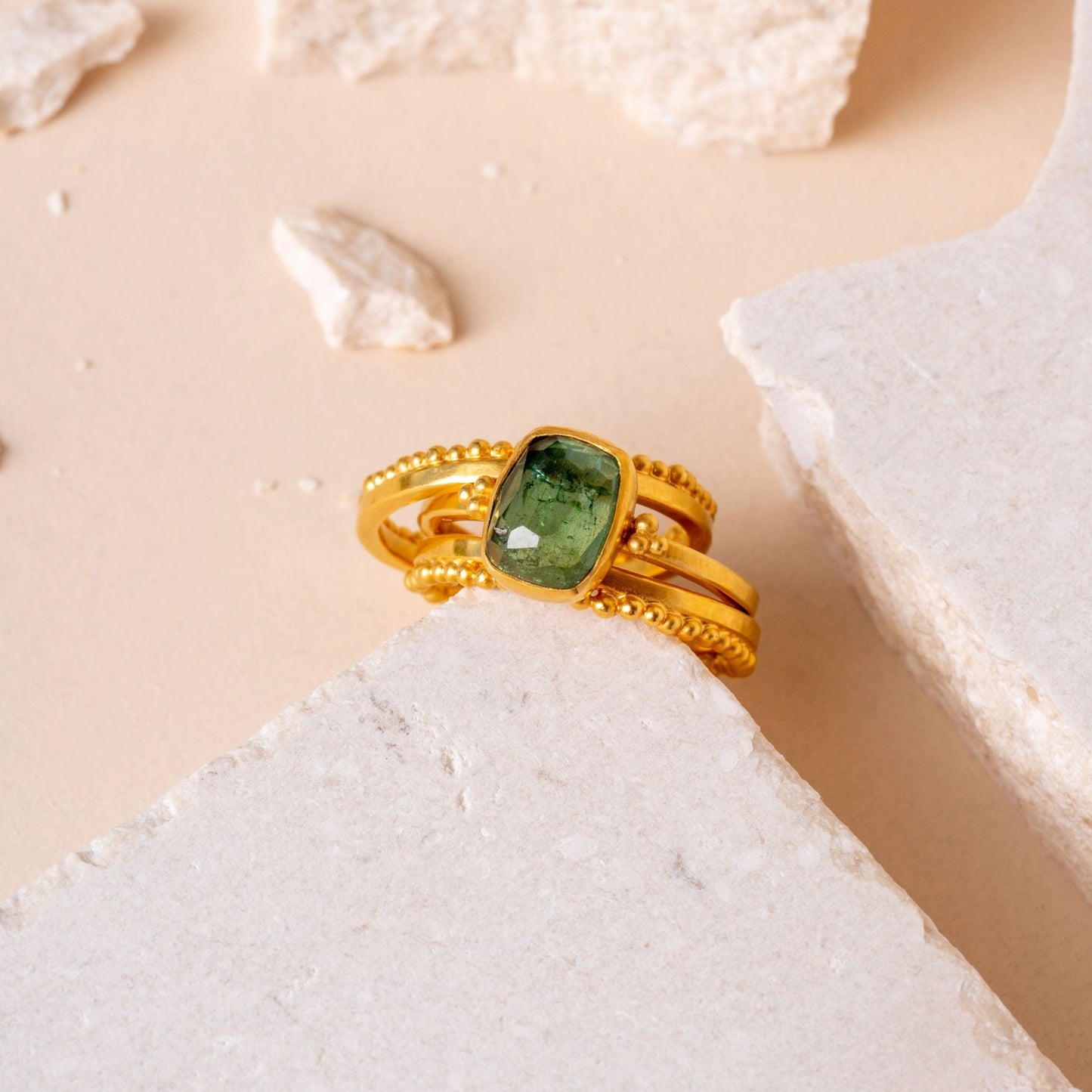 A stunning arrangement of handcrafted gold rings, distinguished by fine granulation work and enriched with the beauty of forest green tourmaline gemstones.