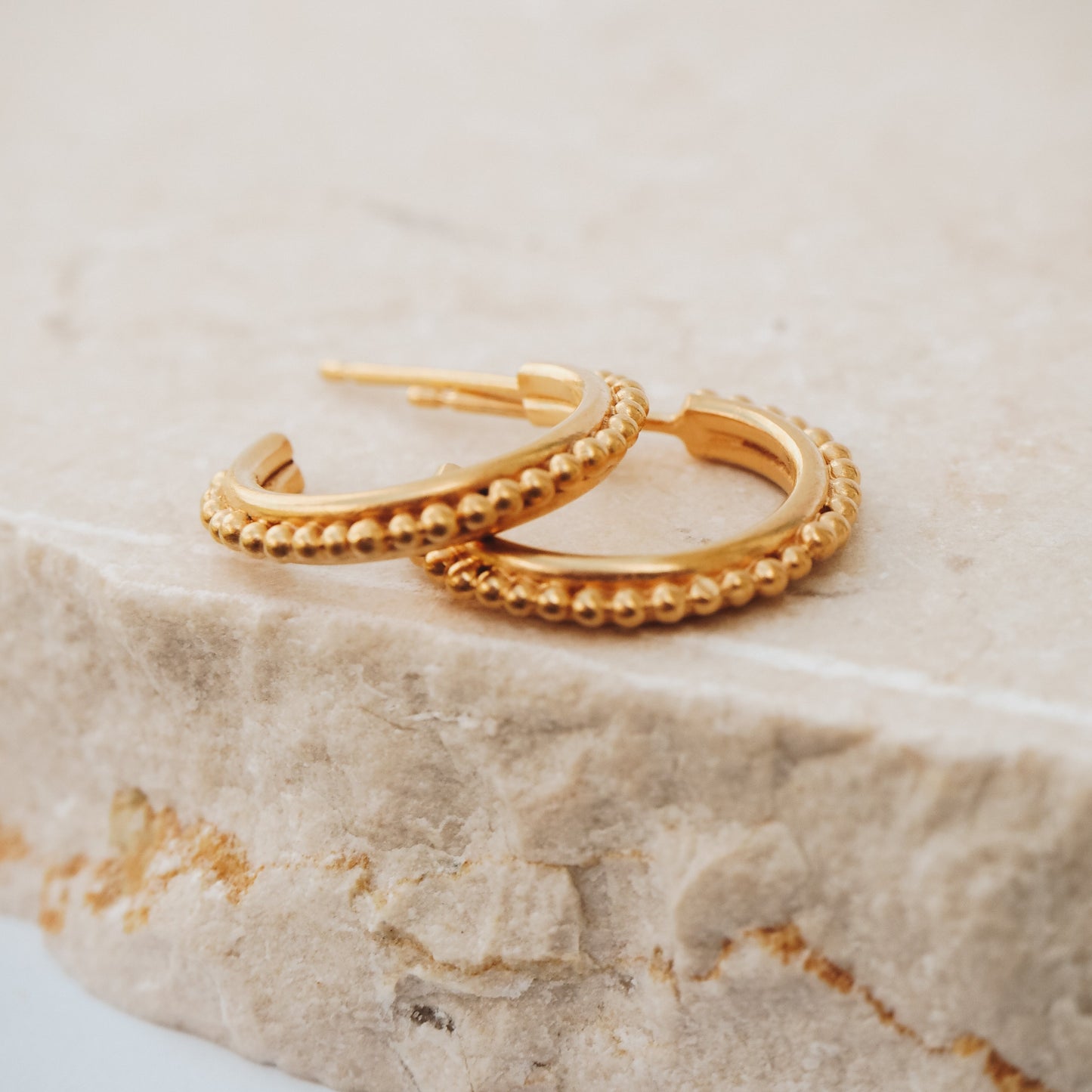 Timeless gold stud hoop earrings featuring granulation detailing, reminiscent of ancient civilisations' jewellery.