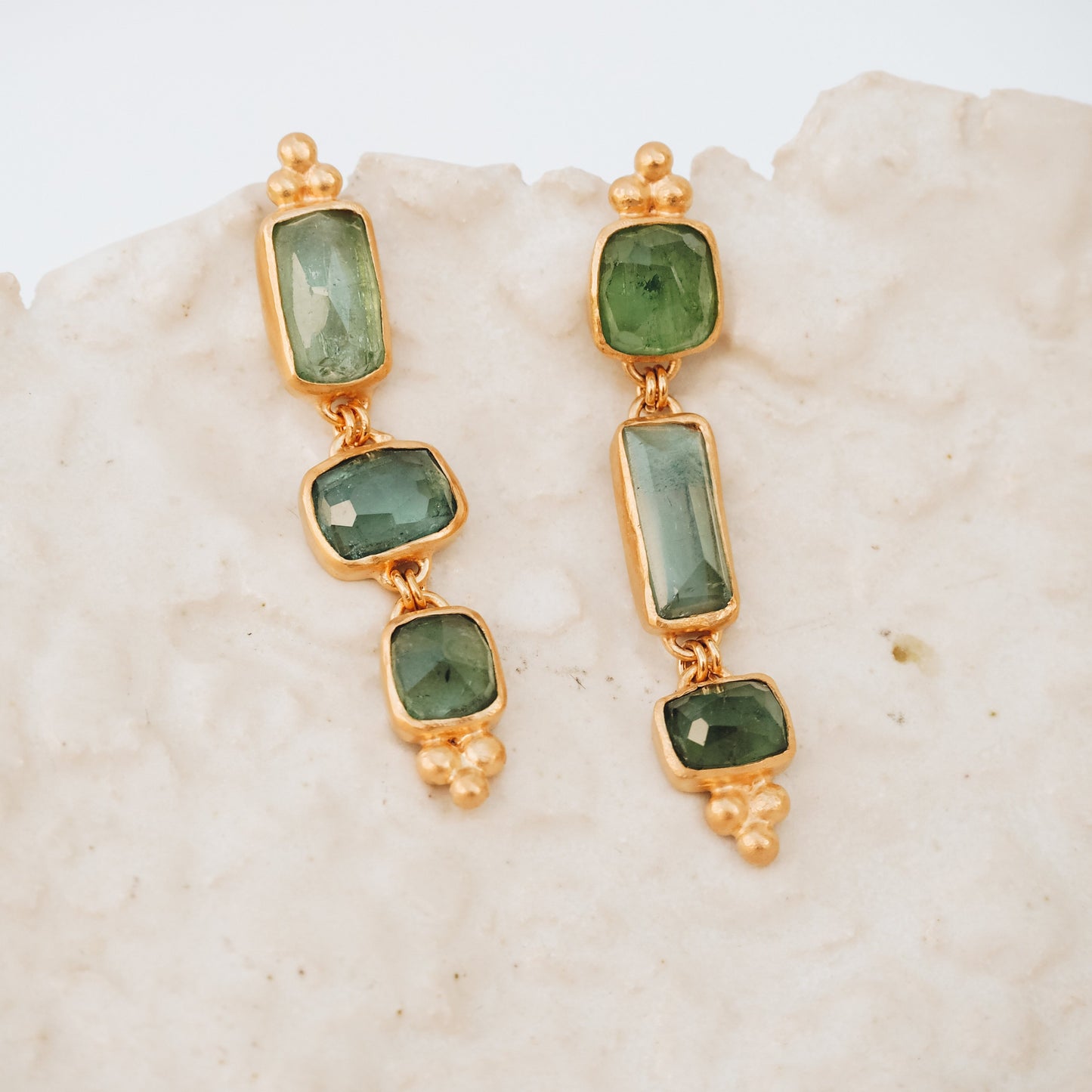 Pair of dainty gold gemstone drop earrings featuring one-of-a-kind square rose cut tourmaline in ocean blue and green, accented with granulation.