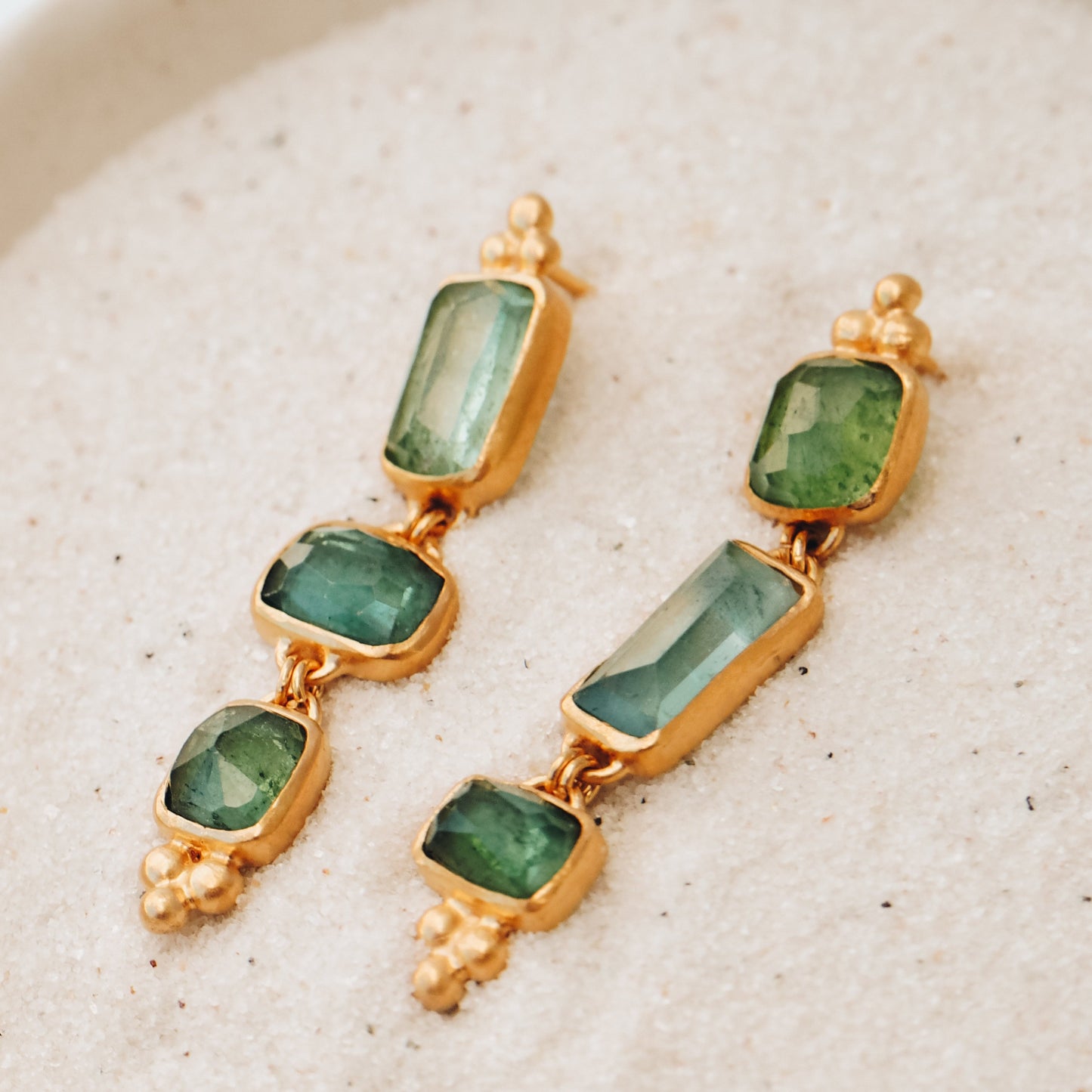 Dainty gold earrings featuring square rose cut tourmaline gemstone drops in ocean blue and green, adorned with exquisite granulation accents
