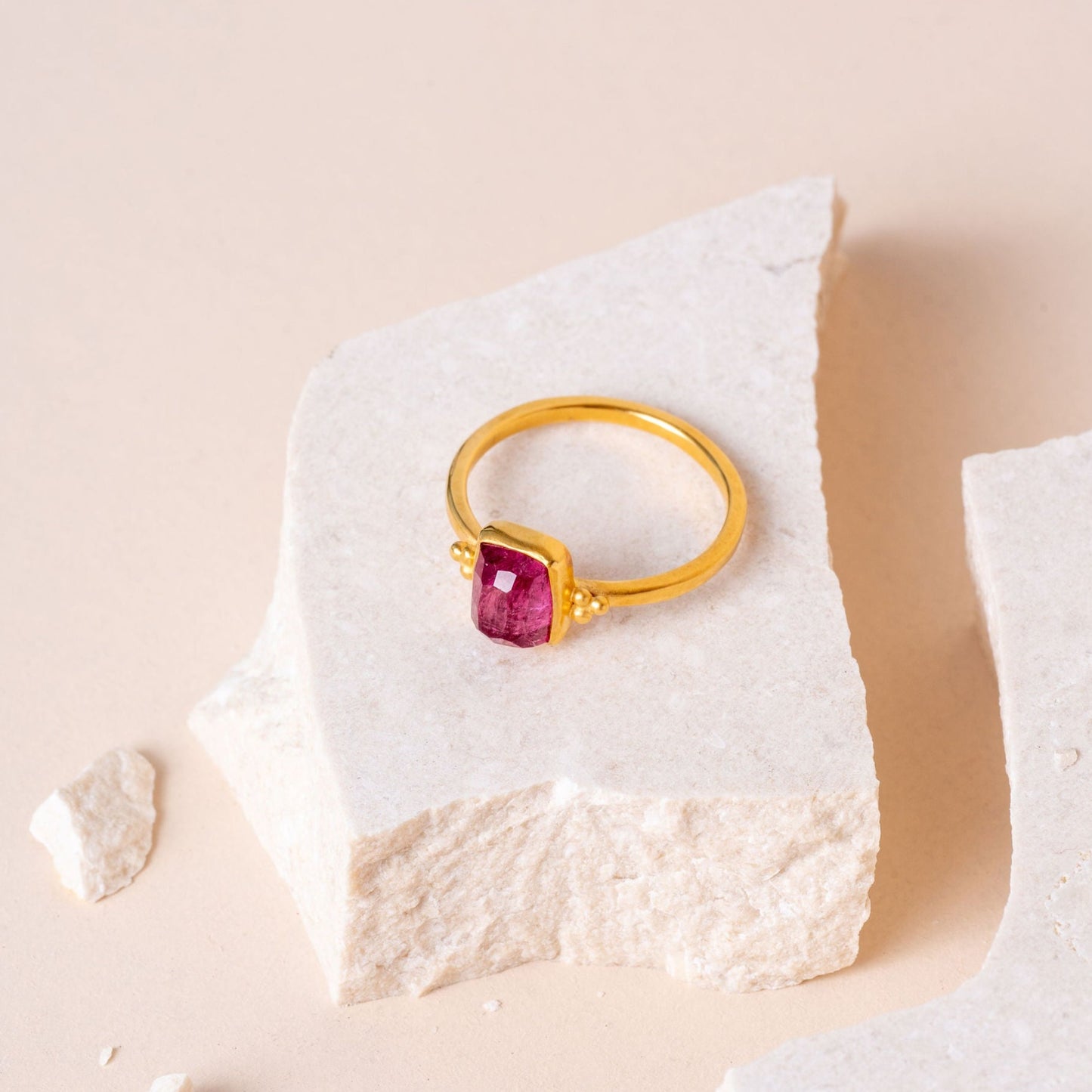 Artisan-crafted gold vermeil ring featuring a hand-cut pink tourmaline, adorned with delicate granulation detailing on each side.